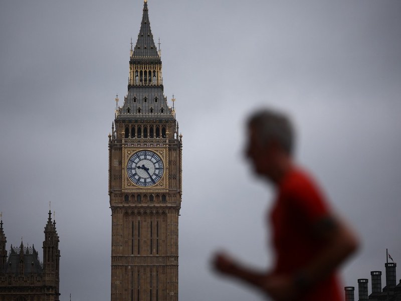 Blurry man running past the Houses of Parliament with big ben in the background