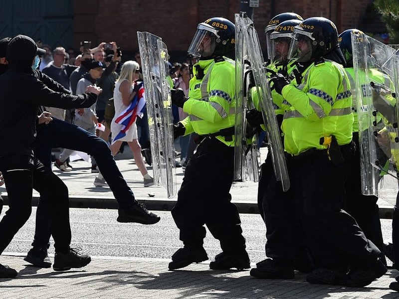 Police officers face protesters outside the Liver Building in Liverpool on August 3, 2024 during the 'Enough is Enough' demonstration held in reaction to the fatal stabbings in Southport on July 29 2024.