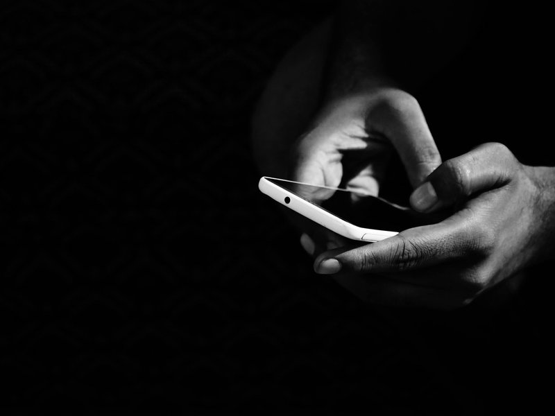 Black and white photo of someone holding a mobile phone