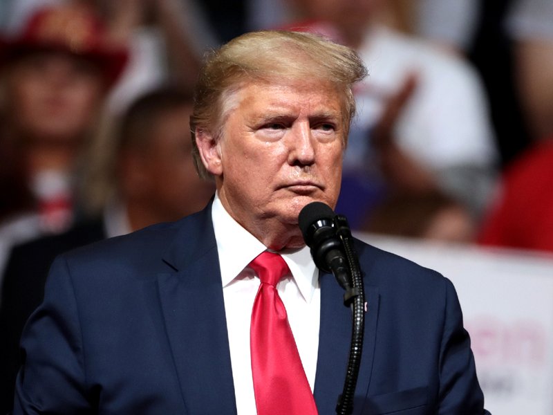 Donald Trump standing at a podium during a rally
