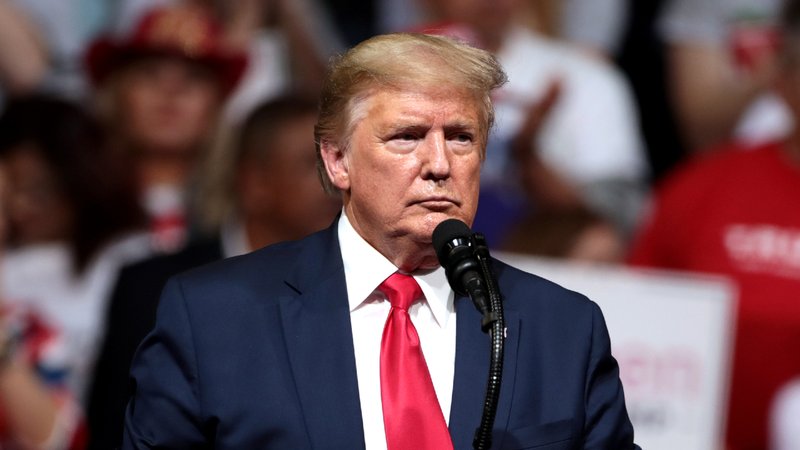 Donald Trump standing at a podium during a rally